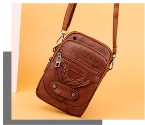 Detail of brown PU leather shoulder bag featuring woven textures and multi-zipper pockets