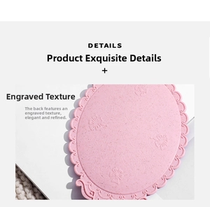 Macro shot of pink vintage hand mirror with embossed floral patterns and wavy edges