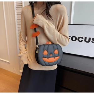 Detail of Halloween pumpkin shoulder bag with bat charms and orange leather face