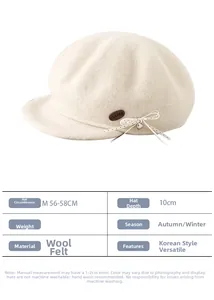 Detailed view of beige wool beret with embossed leather tag and polka dot bow detail
