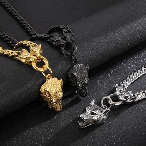 Detailed view of wolf head pendants on Cuban chains in gold, black and silver metal