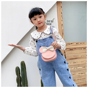 Pink bow girl crossbody bag with cute round ears shown on a child model's outfit