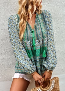 Detail of teal Bohemian print blouse featuring a V-neckline and decorative tassel ties