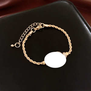Detail of twisted rope bracelet in 18K gold finish with sparkling zircon accents