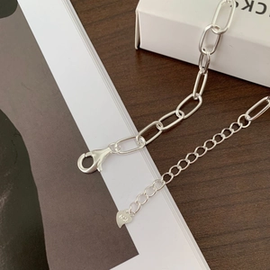 Close-up of S925 sterling silver chain link necklace with lobster clasp and heart charm