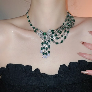 Macro detail of emerald-style multi-layer tassel necklace with a bow knot design