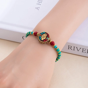 Détail d'un bracelet bohème vintage avec perles turquoise et pendentif nuage gravé