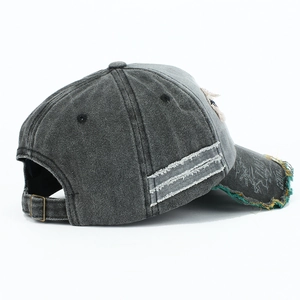 Detailed side view of washed distressed baseball cap with ripped edges and metal buckle
