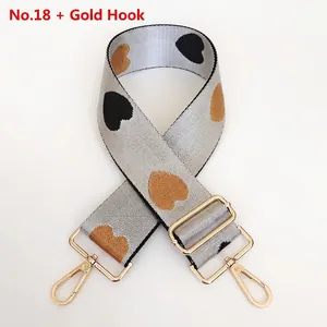 Close-up of thick nylon bag strap with heart jacquard pattern and gold swivel hooks