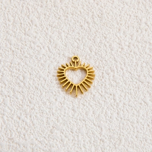 Detailed view of sunburst heart pendant in 18k gold plating with hollow center design