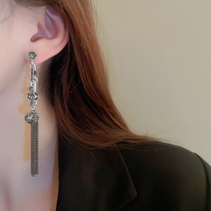 Close-up of vintage silver tassel earrings with dark rhinestones on a female model