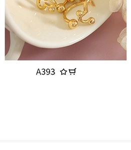 Close-up of gold-plated titanium steel twisted hoop earrings in a white ceramic bowl