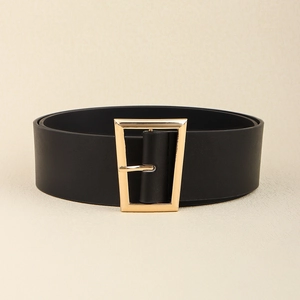 Macro detail of black leather waist belt featuring a geometric gold rectangular buckle