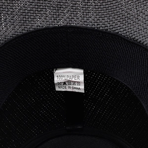 Detail view of the 100% paper material washing label inside the black straw cowboy hat