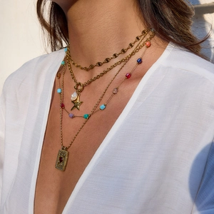 Layered gold chain necklace with starfish and tarot card pendants on model