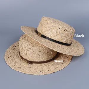 Close-up of raffia straw hat texture with leather band and gold metal buckle