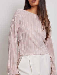 Detail of mauve plissé pleated fabric with delicate vertical textures and ruffle hem