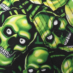 Macro detail of the fluorescent green skull pattern on black twill fabric of the bucket hat