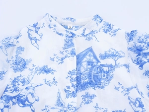 Detail des blauen Engel-Prints und des kleinen Stehkragens am weißen Chiffonkleid