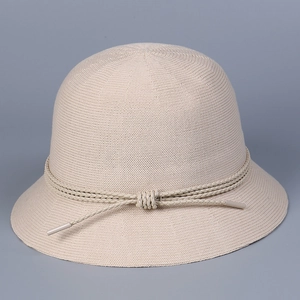 Detailed close-up of a beige knit bucket hat with decorative braided rope and knot design