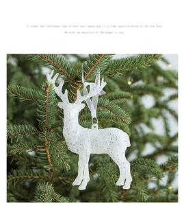 Nahaufnahme von weißem Rentier-Ornament mit Glitzer an einem Weihnachtsbaum hängend
