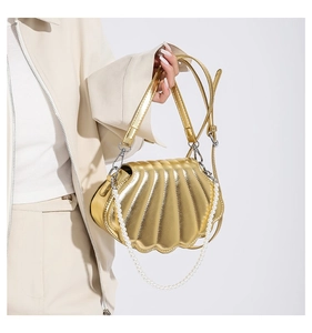Detail der gold metallic Muscheltasche mit Perlengriff und verstellbarem Gurt