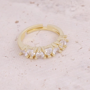 Detailed view of adjustable gold ring with five heart-shaped white cubic zirconia stones