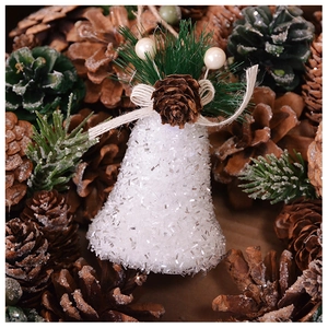 Vue détaillée d'une cloche flocon de neige blanche avec pommes de pin et verdure de Noël