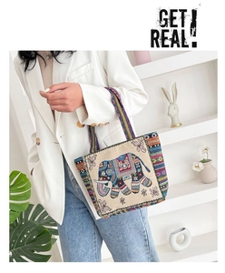 Close-up of elephant embroidery and colorful woven straps on ethnic canvas tote bag