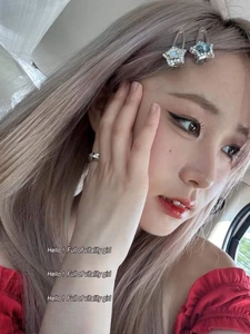 Detail showing blue and white rhinestones on star-shaped hair clips and silver ring on model