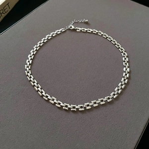 Close-up of silver geometric link chain necklace with lobster clasp and adjustable links