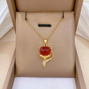 Elegant gold fox pendant necklace with red gemstone and white zircons on velvet box