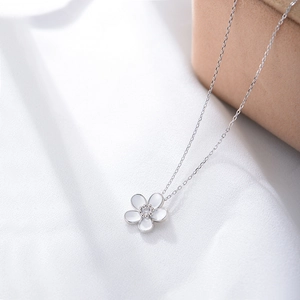Macro detail of S925 silver flower pendant necklace with white enamel and sparkling zircon