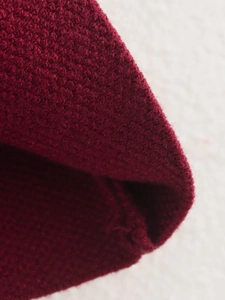 Makroaufnahme der dicken roten Strickstoffstruktur und hochwertigen Webmuster-Details