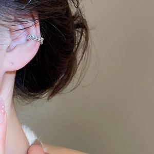 Close-up of sparkling cubic zirconia leaf ear cuff on model for non-pierced ears