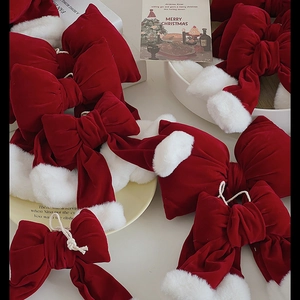 Festive red velvet Christmas bow with white faux fur trim on a holiday themed background