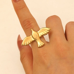 Close-up of a gold hollow bird ring with adjustable opening worn on a finger