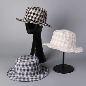 Detail of plaid linen bucket hats showing fabric texture and color variations in studio