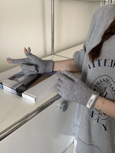 Detail of grey knitted gloves with touchscreen-friendly open thumb and index fingers