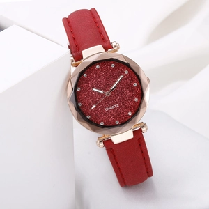Detailed close-up of rose gold starry watch with red glitter dial and crystal markers