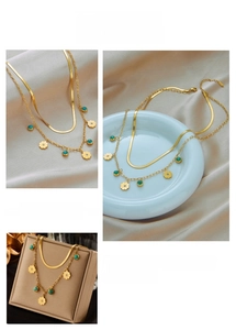 Detail of gold double-layer snake chain necklace with turquoise floral pendant