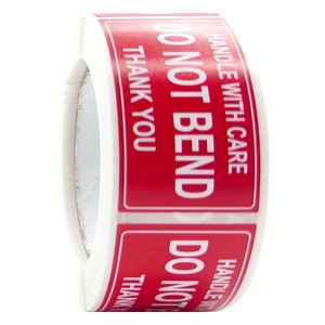 Detail of red fragile adhesive shipping labels roll with handle with care warning text