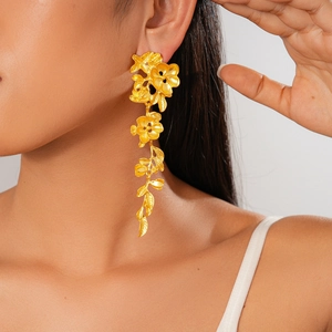 Gros plan d'une boucle d'oreille fleur dorée vintage portée par un mannequin