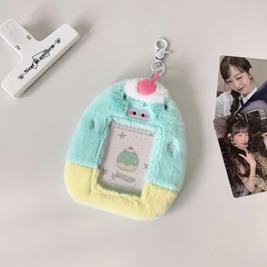 Close-up of plush photo card holder with mint and yellow contrast and pink ball charm