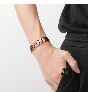 Close-up of a brown magnetic stainless steel energy bracelet worn on a man's wrist