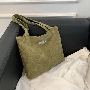 Detail view of the green corduroy tote bag showing the textured fabric and Fashion label