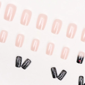 Faux ongles pailletés noir et rose avec motifs de rennes de Noël sur un fond blanc propre