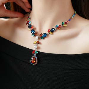 Detailed view of model wearing a vintage Y-shaped necklace with colorful teardrop crystal