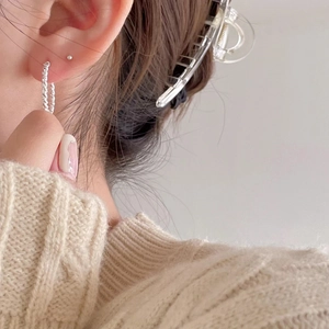 Minimalist S925 sterling silver twisted hoop earrings worn by a model in a warm sweater