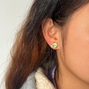 Detailansicht luxuriöser ovaler Ohrstecker mit Zirkon-Steinen am Ohrläppchen